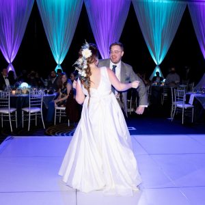 bride and groom dancing under blue and purple lights
